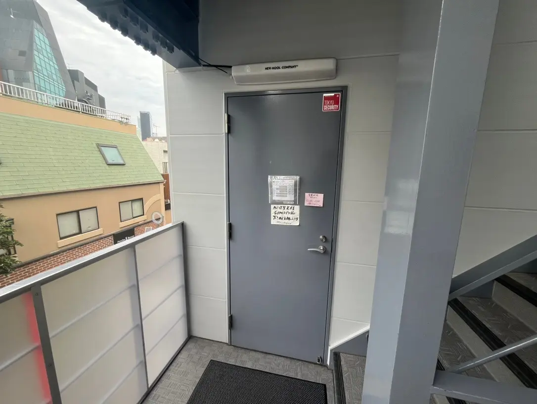 ビルの緊急避難階段と防火扉、安全に関する注意書きが貼られた都市のオフィスビル外観