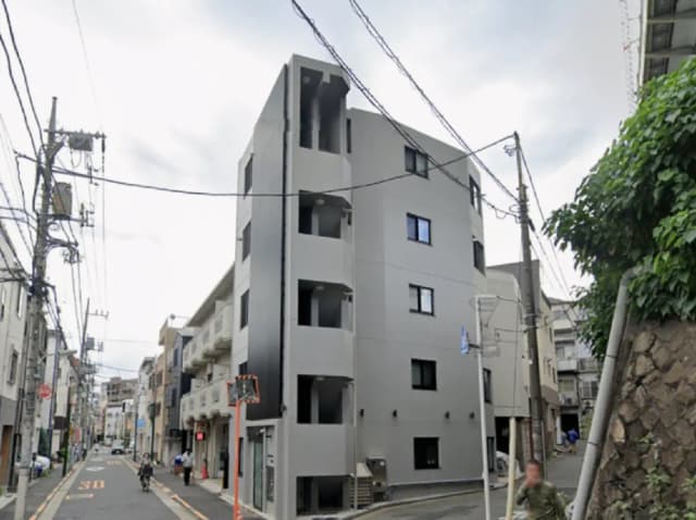 - 現代的なデザインのマンション外観、街道に面し、周囲の建物と共存するシンプルな構造の集合住宅