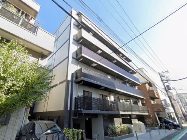 - 都市型マンションの外観、モダンなデザインとバルコニー、緑豊かな植栽が特徴的な景観