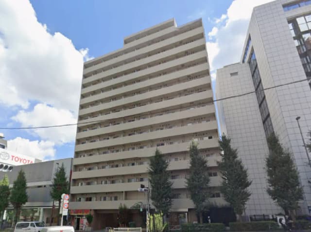 - 現代的なデザインのマンション外観、白い外壁と緑の植栽が特徴的な7階建てのビル
