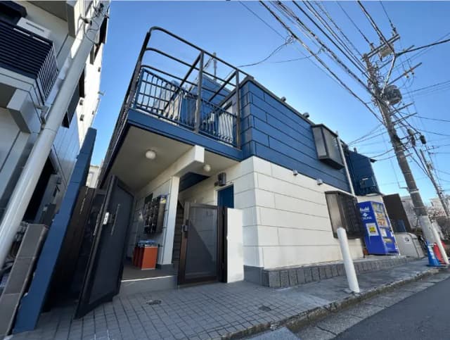 電線が見える晴れた日の住宅街の現代的なブルーの二階建て建物