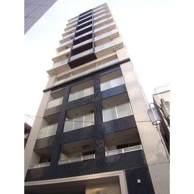 - 現代的な外観の高層マンション、黒と白のデザインタイル、バルコニーが特徴的な建物の正面画像