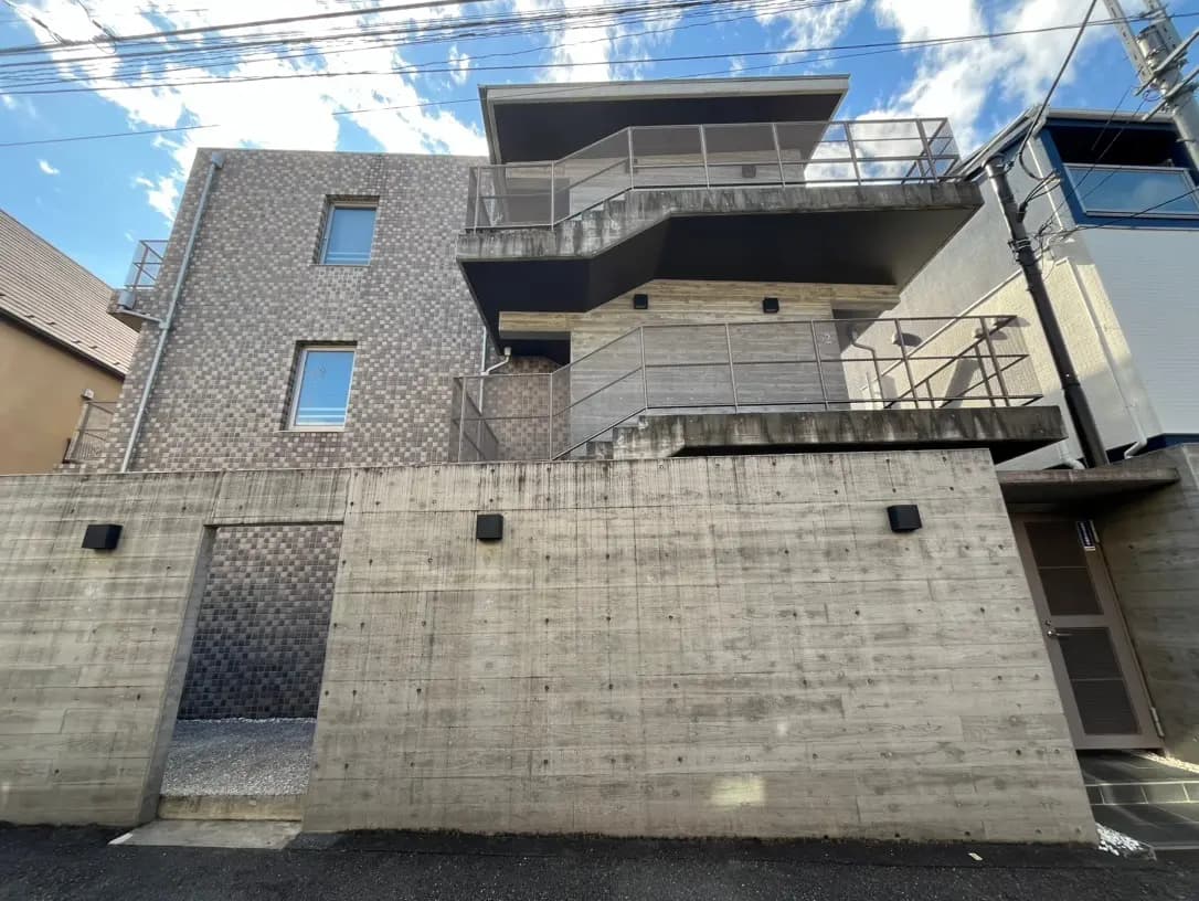 現代的な外観を持つ複数階建てのアパート、タイル張りのファサードとバルコニーが特徴的な建築デザイン