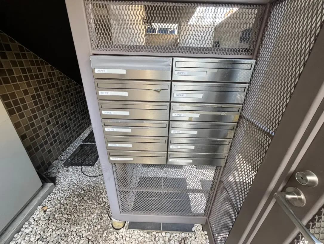 メタルメッシュのドアと現代的なアパートの郵便受けボックス