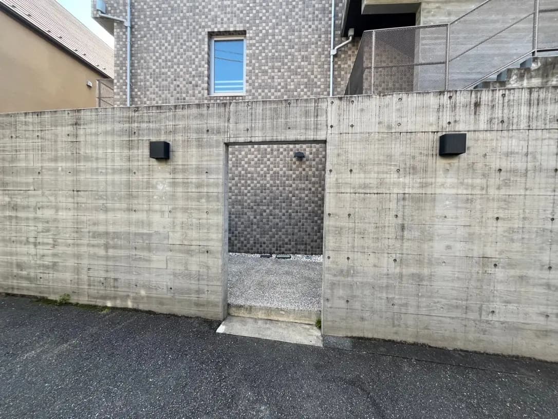 コンクリート壁に囲まれた現代的なデザインの外壁とエントランスゲート