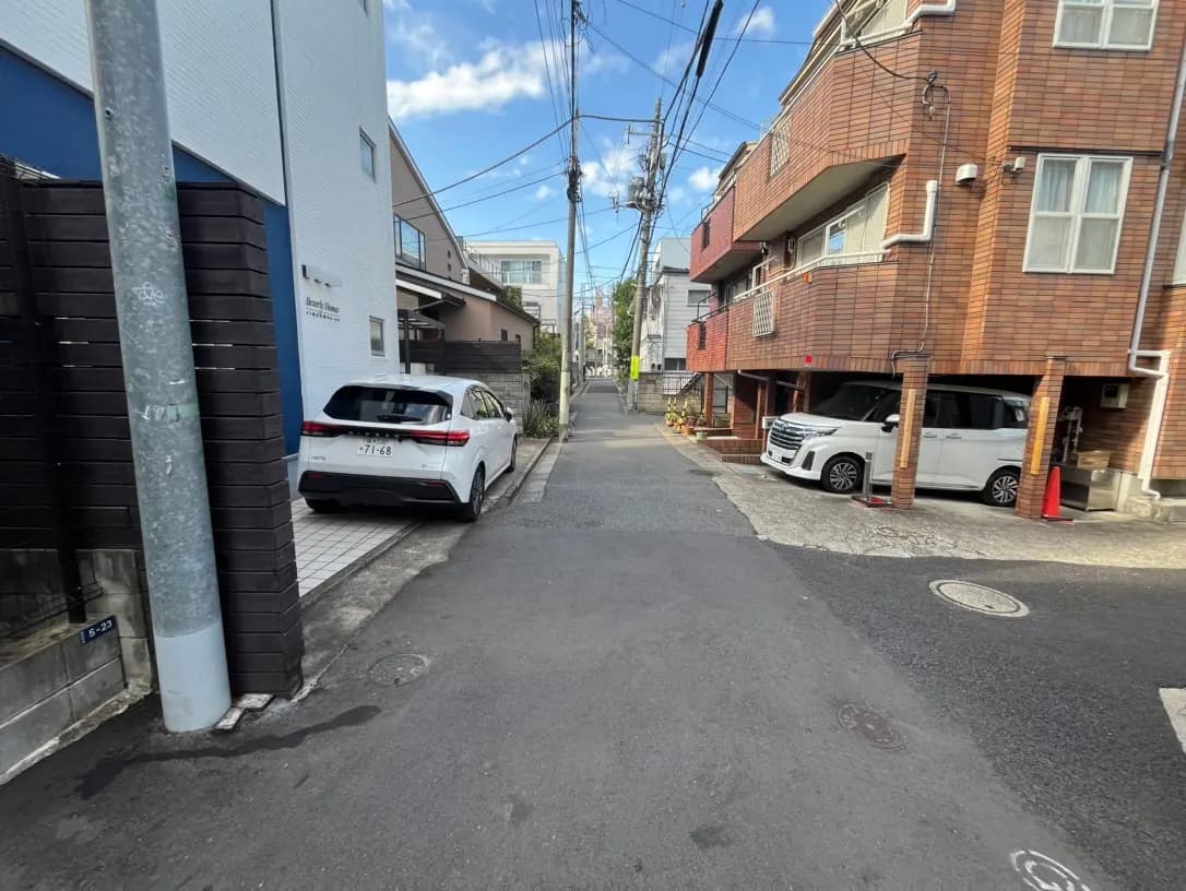 日本の住宅街の狭い道路、駐車された車、アパートメントの外観