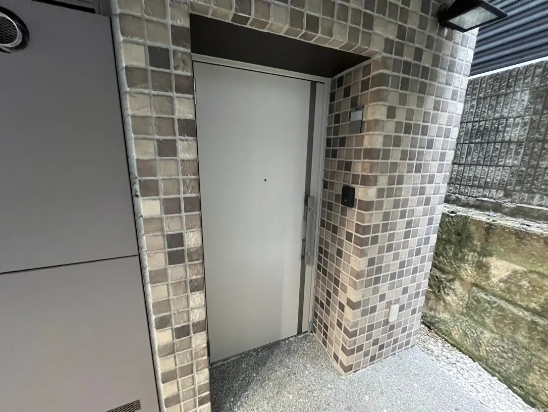 現代的なタイル張りのエントランス、セキュリティシステム付き白い扉、都市部の住宅の入り口デザイン