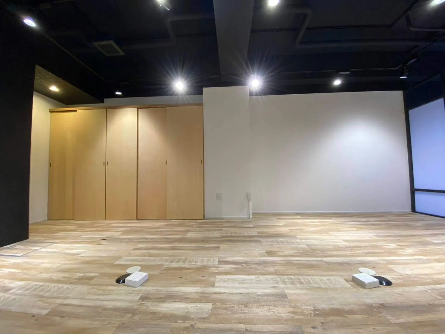 シンプルなデザインの空き部屋、木製床材、埋め込み型照明のモダンインテリア