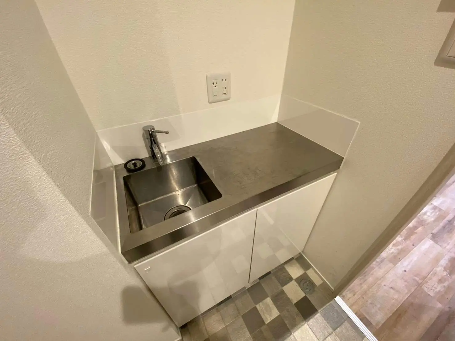 シンプルなデザインのステンレス製キッチンシンク、モダンな白いキャビネット付き