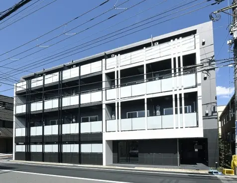 - 現代的なデザインの複合アパートメントビル、ガラスバルコニーと大きな窓を備え、青空の下に立つ外観