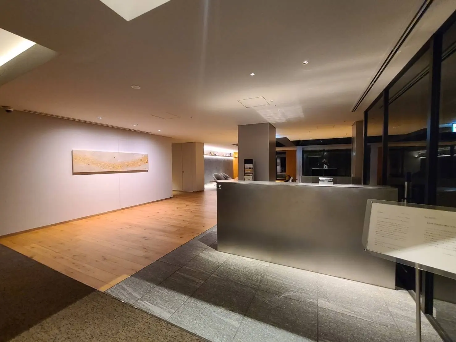 現代的なスタイルのロビー、木製フローリング、アート装飾壁画、柔らかな照明のインテリアデザイン