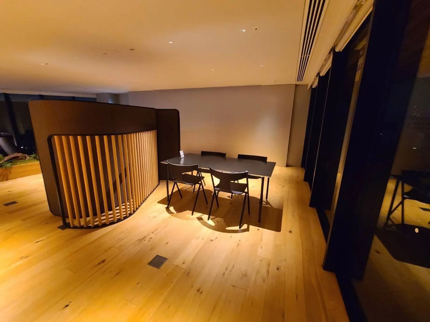 シンプルでスタイリッシュなデザインのオフィススペース、天然木のフローリング、ガラス壁からの景色