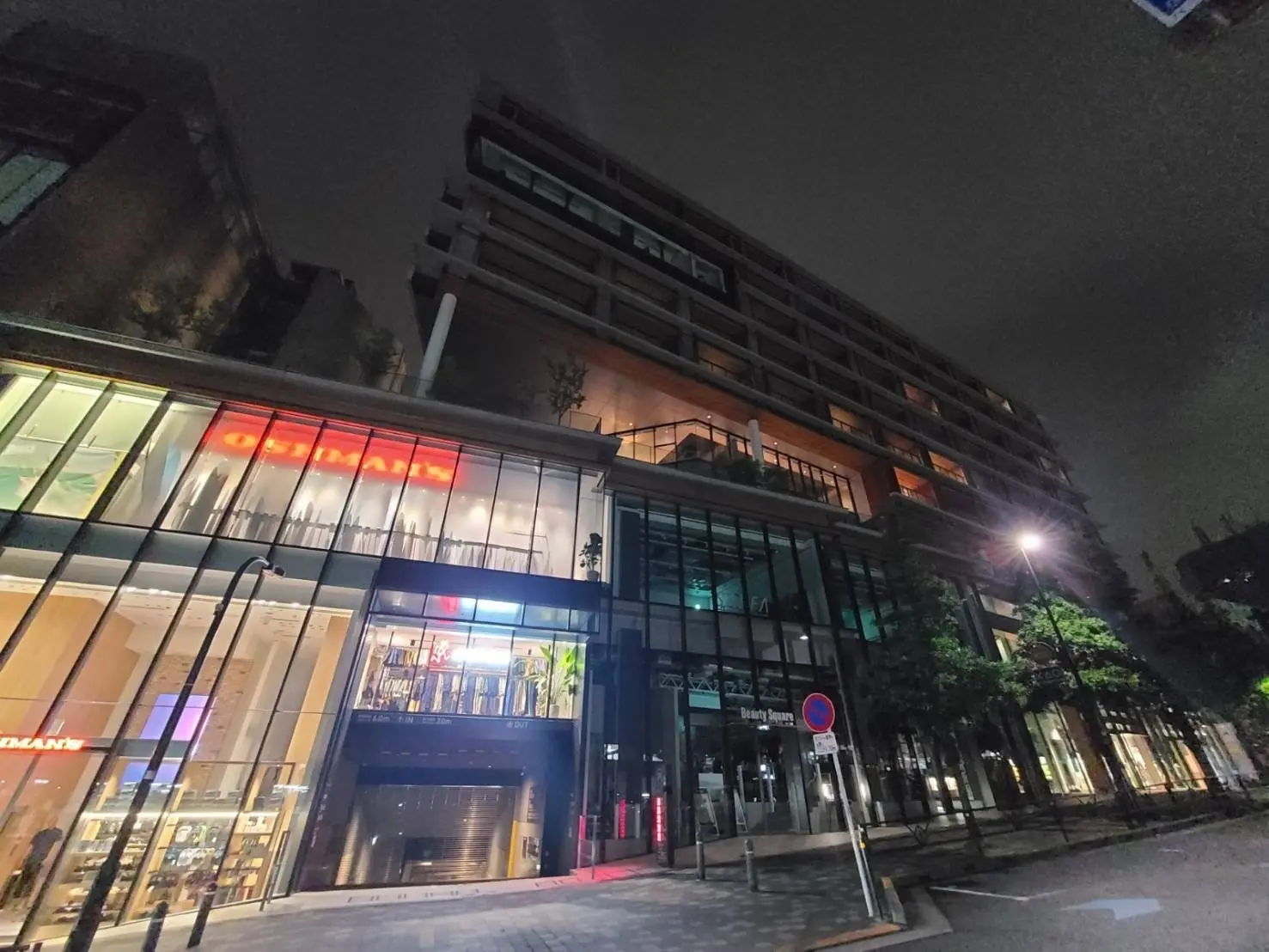 夜の街並みとモダンな建築物、ガラス張りのファサードと照明が映える商業ビル