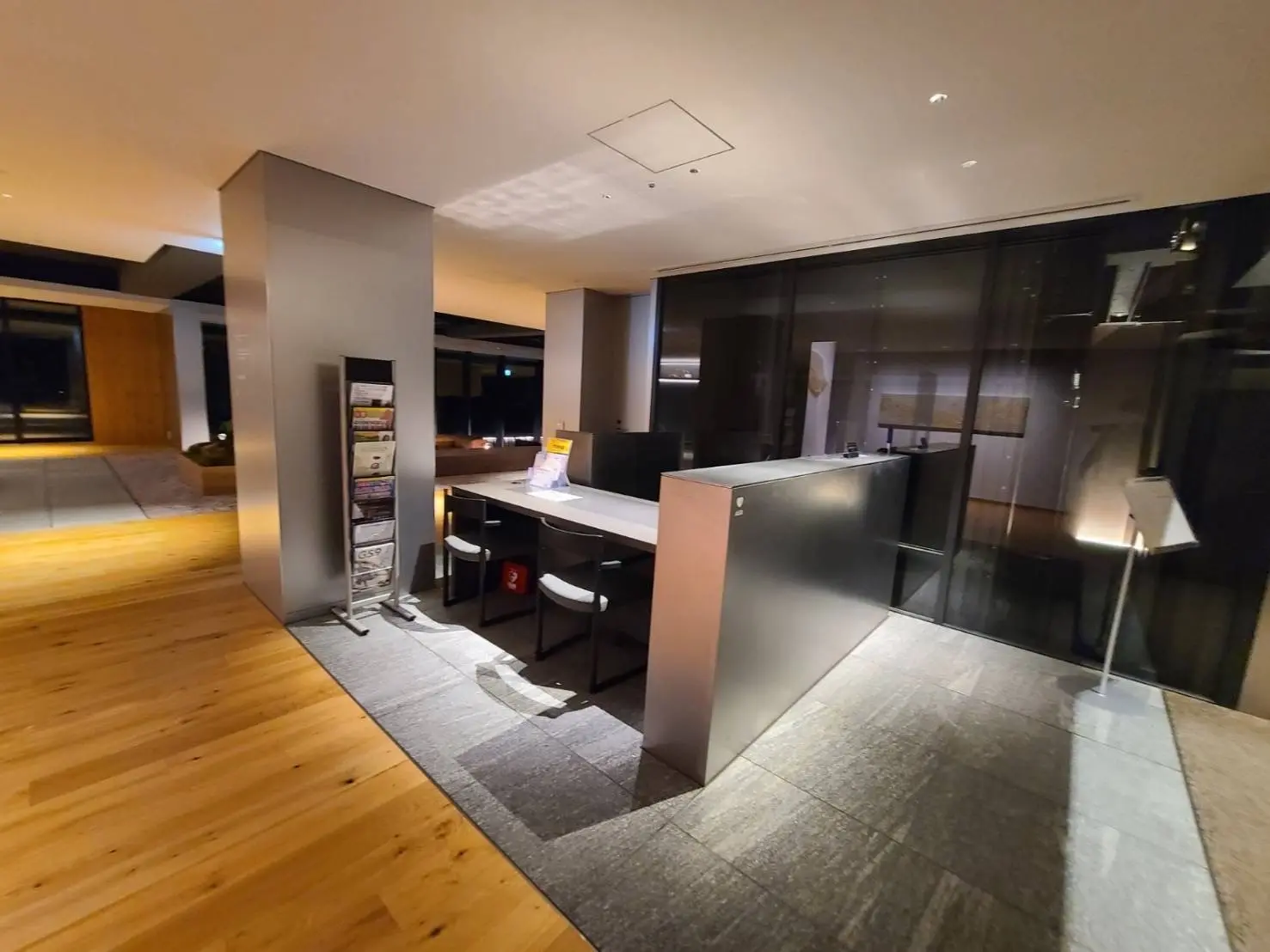 モダンなオフィス空間、ウッドフローリングと黒いキャビネット、明るい照明とシンプルなデザイン