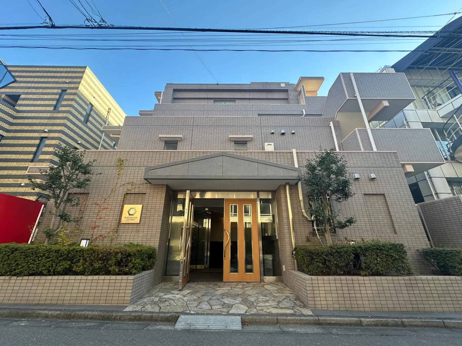 モダンな外観の都市型ビジネスホテル、CATALIAの看板とエントランス、周囲には高層ビルと緑の植栽