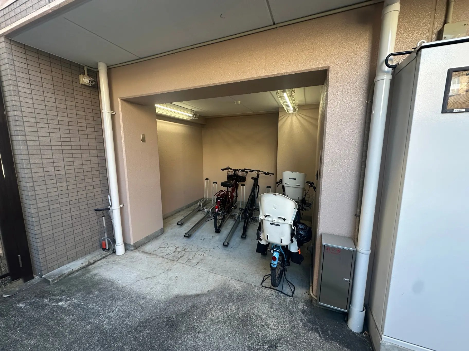 屋根付き駐輪スペース、家庭用電動自転車やママチャリが置かれている外観