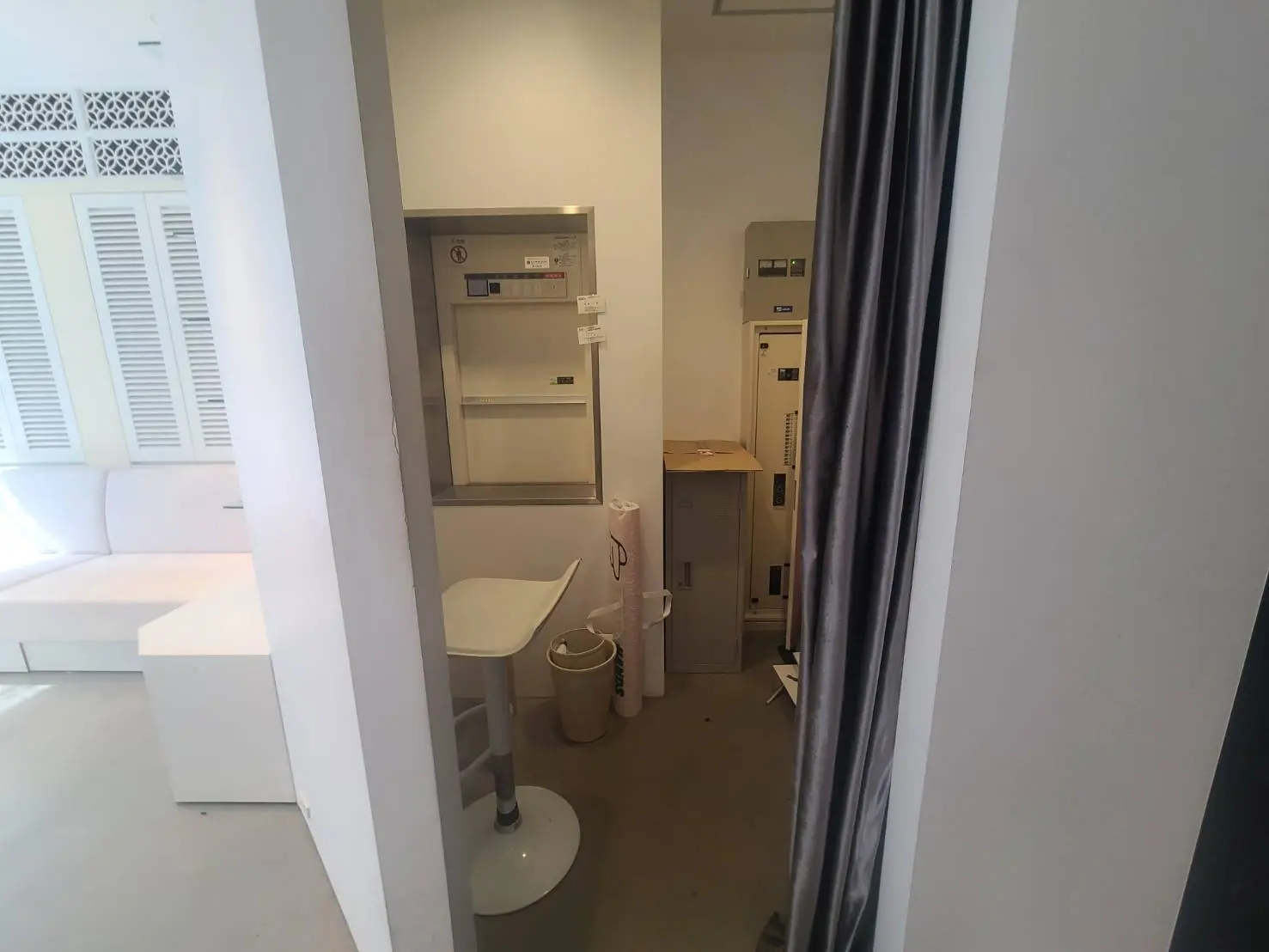 白色を基調としたシンプルな待合室、白いソファーとバーテーブルが設置されたリラックス空間