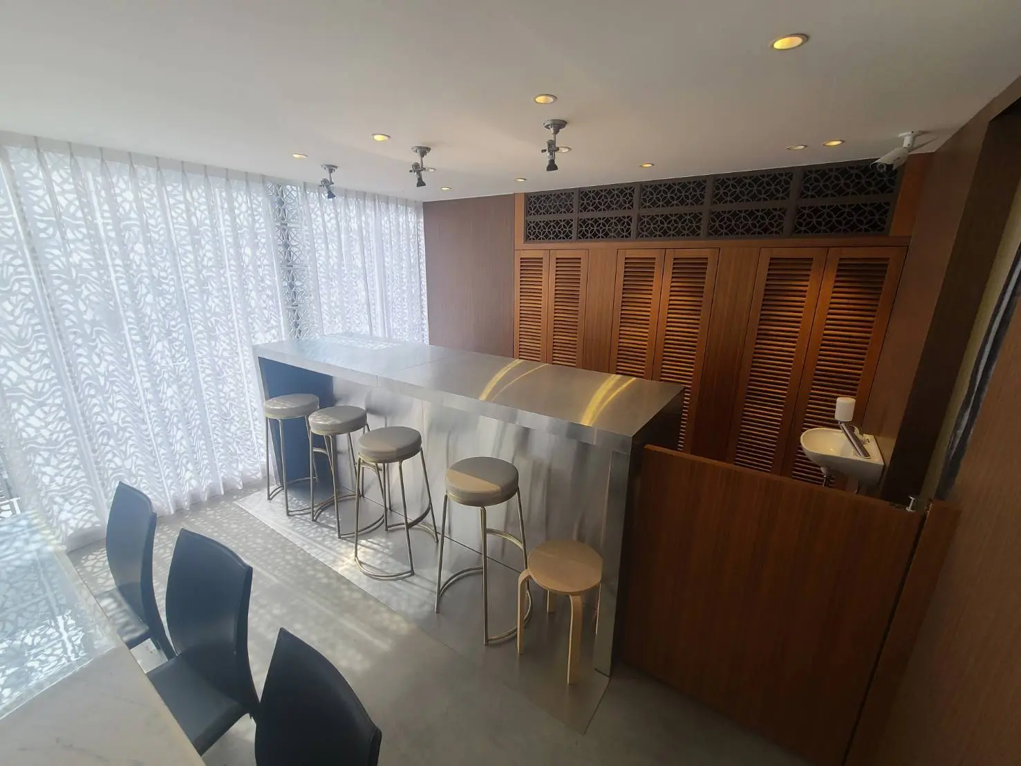 モダンなキッチンバーカウンター、洗練されたインテリア、天然光が差し込む透かし彫りのカーテン