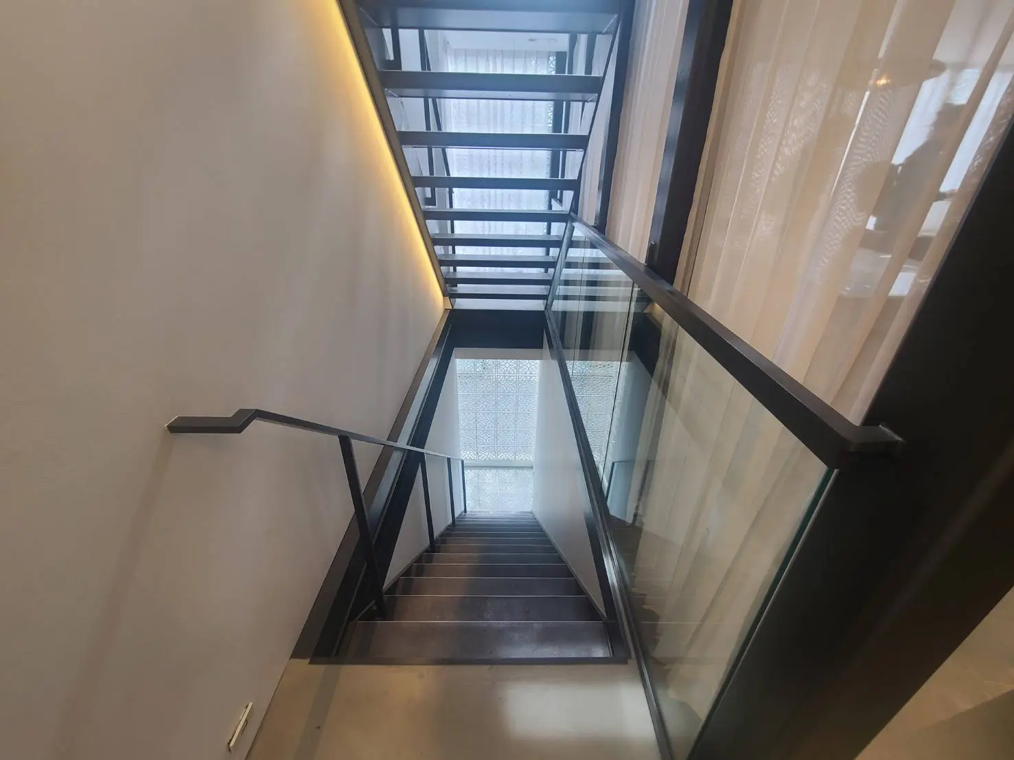 モダンなインテリアの階段、ガラスの手すり、シンプルなデザイン、自然光が差し込む空間