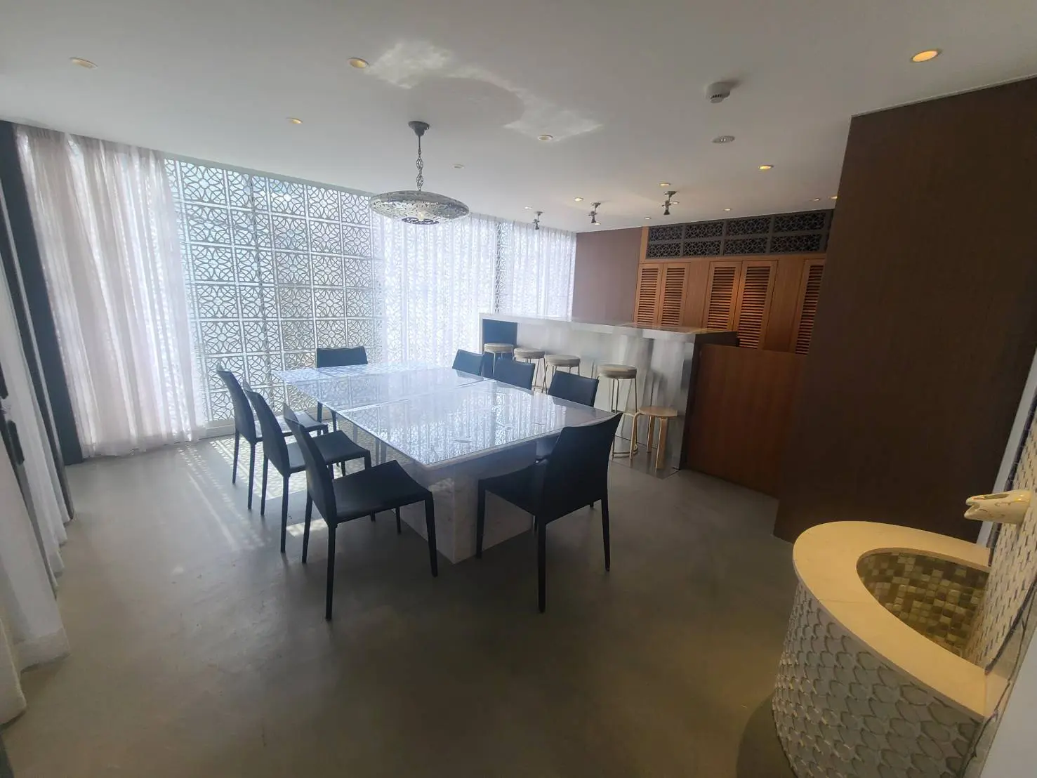 モダンなダイニングルーム、ガラスのダイニングテーブルと黒い椅子、明るい窓とシックなインテリアデザイン