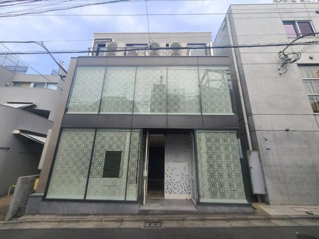 現代的な外観のビルディング、独特なデザインのパターンを施したガラス窓、コンクリートの壁