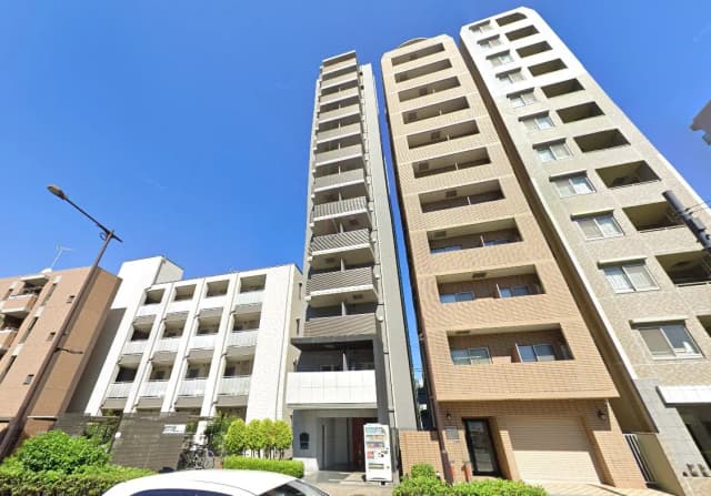 - 青空の下に立ち並ぶ現代的なマンションビル、異なるデザインの外観が特徴的な住宅街の風景