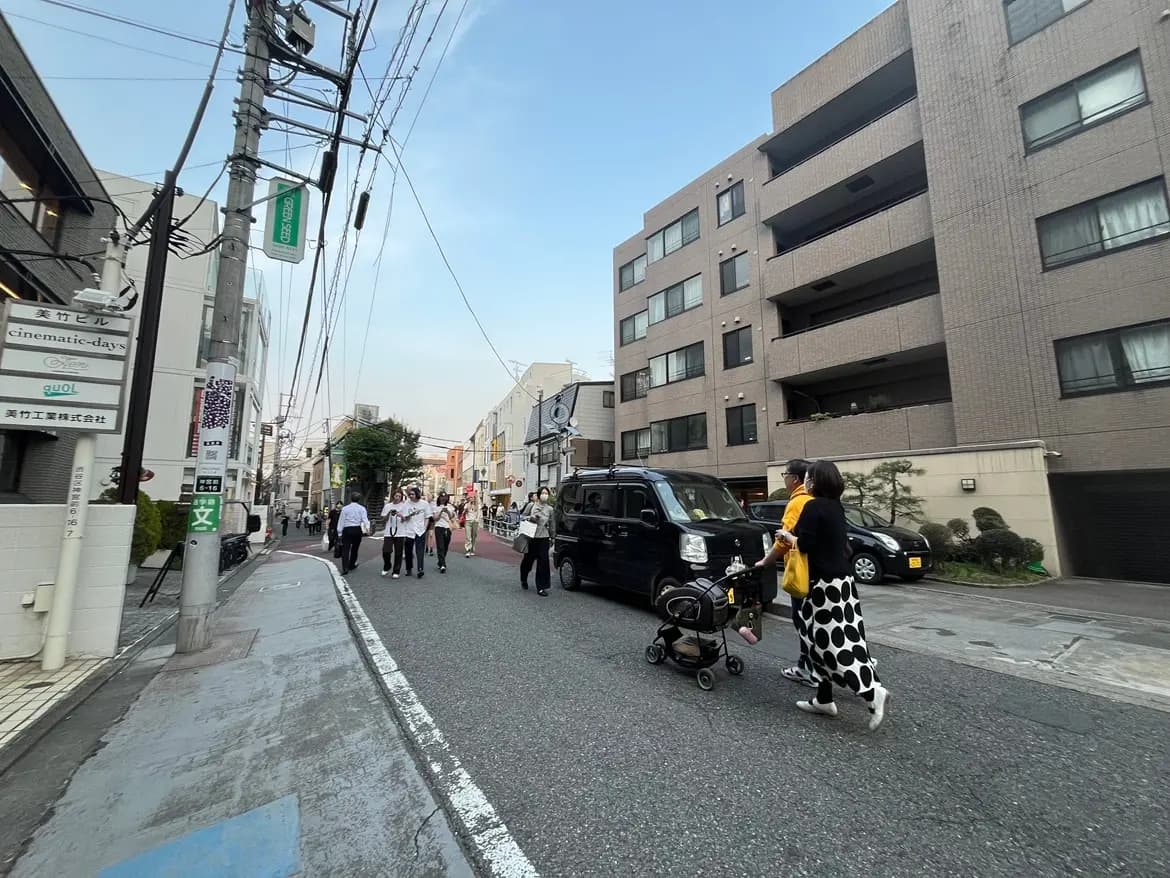 日本の都市の街並み、歩行者と赤ちゃんを乗せたベビーカー、道路沿いの建物と電柱