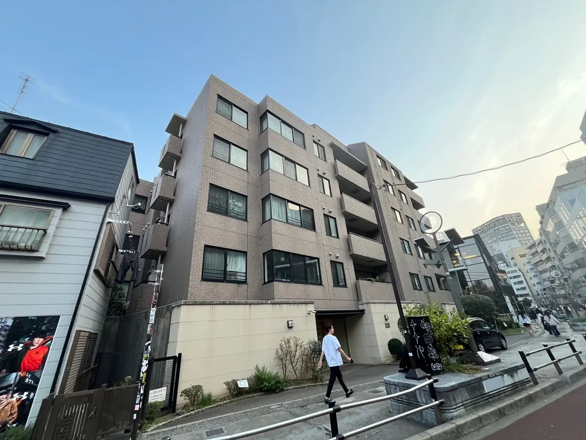 現代的な外観の都市型マンション、歩行者と街の風景、晴れた日の早朝または夕方