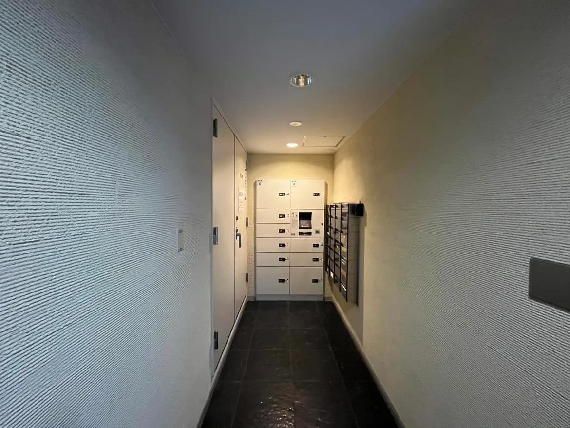 現代的なデザインの集合住宅のエントランスホール、壁面の郵便受け、タイルの床