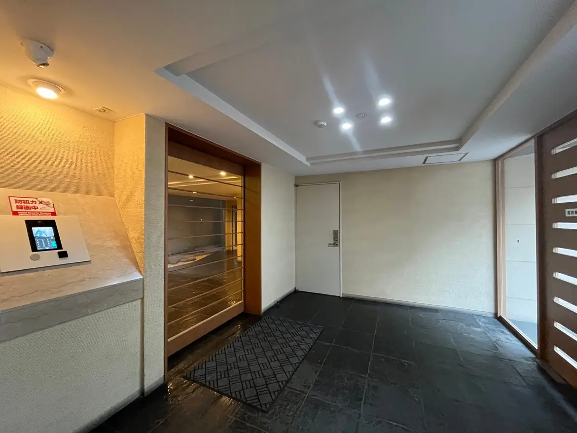 現代的なエントランスホール、インターホンとメールボックス付き、明るいダウンライトの照明