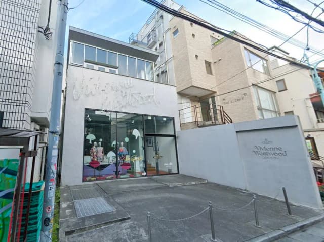 - ヴィヴィアン・ウエストウッドの店舗外観、モダンなデザインの建物と大きなガラス窓、エントランスとサインが特徴的なファッションブティック