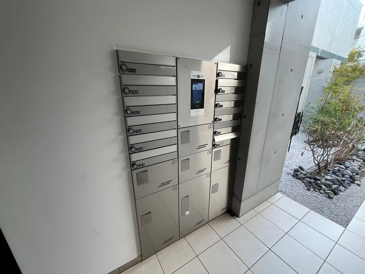 - 近代的なデザインのポストボックス、電子パネル付きで複数のロッカーがあるエントランスの風景