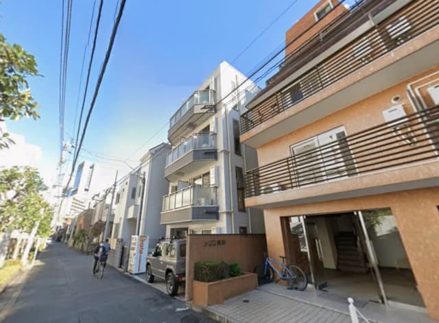 - 都会的な住宅街に位置する現代的なアパートメント、バルコニーとオープンエントランス、電線のある風景