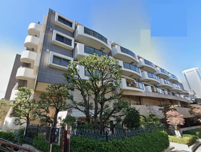 - モダンな外観のマンション、緑豊かな庭とテラスバルコニーを備えたデザイン、晴れた青空を背景にした写真