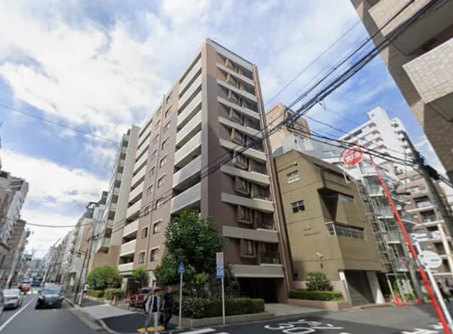 - 都会のマンション街、モダンなデザインの建物が立ち並ぶ風景、青空と電線が見える通りの景観