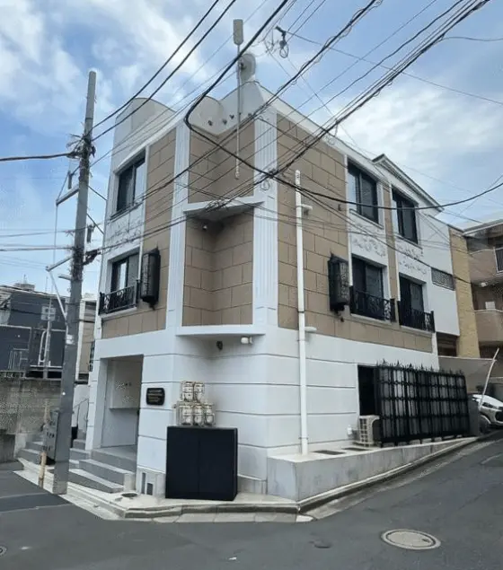 - 革新的なデザインの外観を持つ三階建ての住宅、周囲に電線が多数通り、落ち着いた雰囲気の街中に位置する