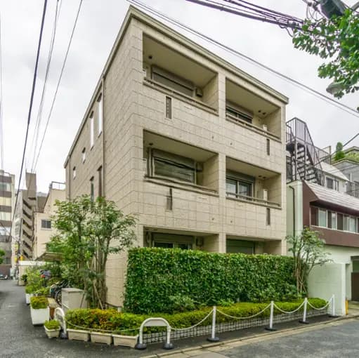 - モダンな外観の3階建てマンション、緑の植栽に囲まれたエントランスのある街中の風景