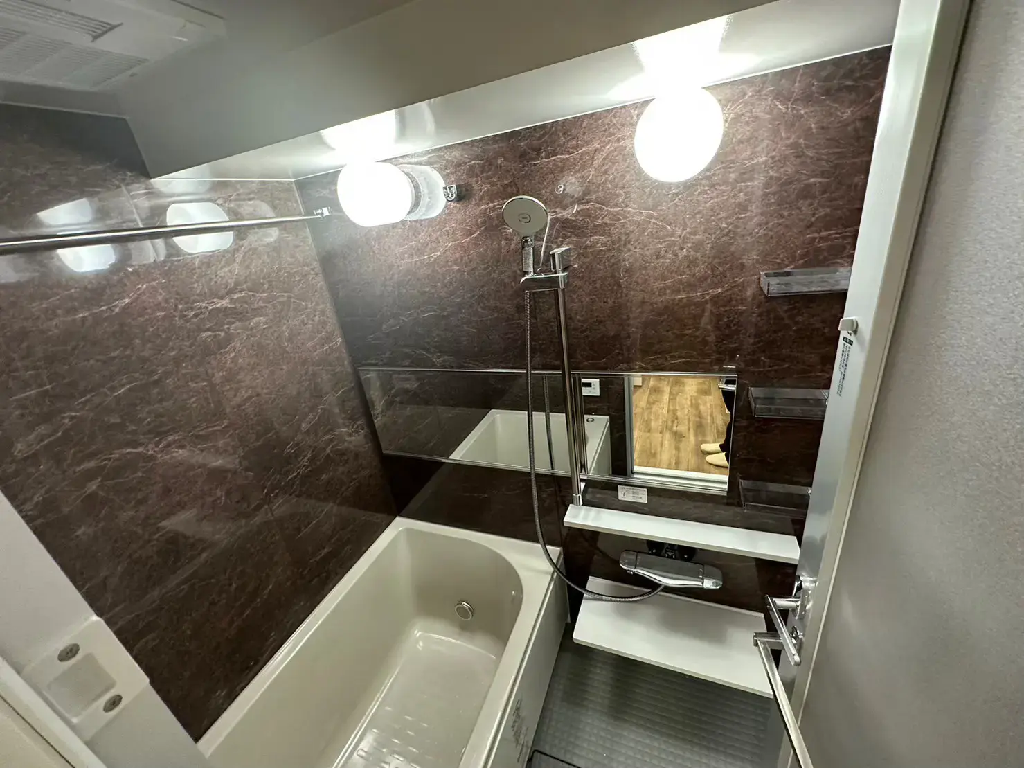 マーブル調の壁が特徴的な洗面所とバスルーム