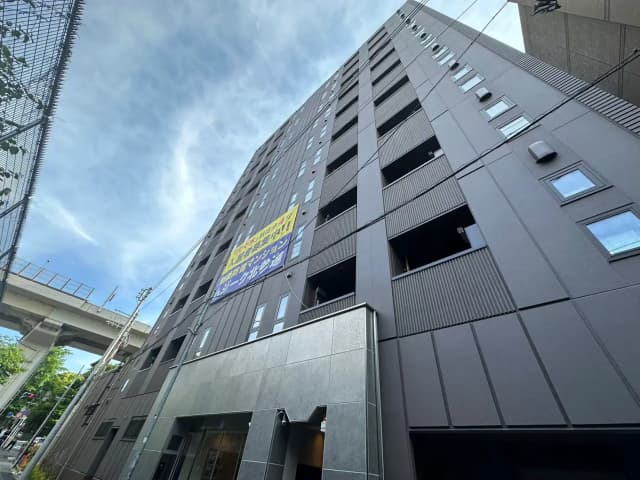 モダンなデザインのダークグレーのビル外観、都会的な立地