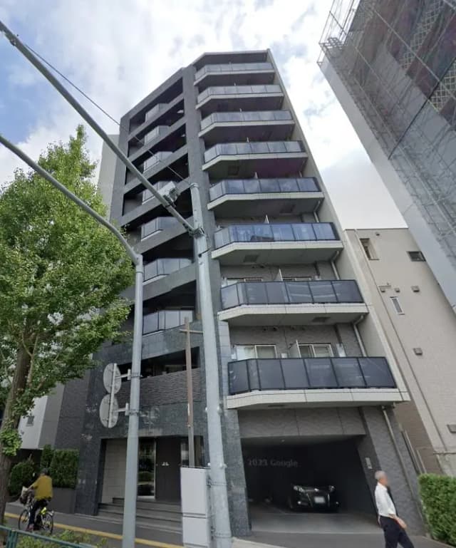 現代的なデザインの都市型マンション、バルコニー付きの外観、緑豊かな街路樹と歩行者