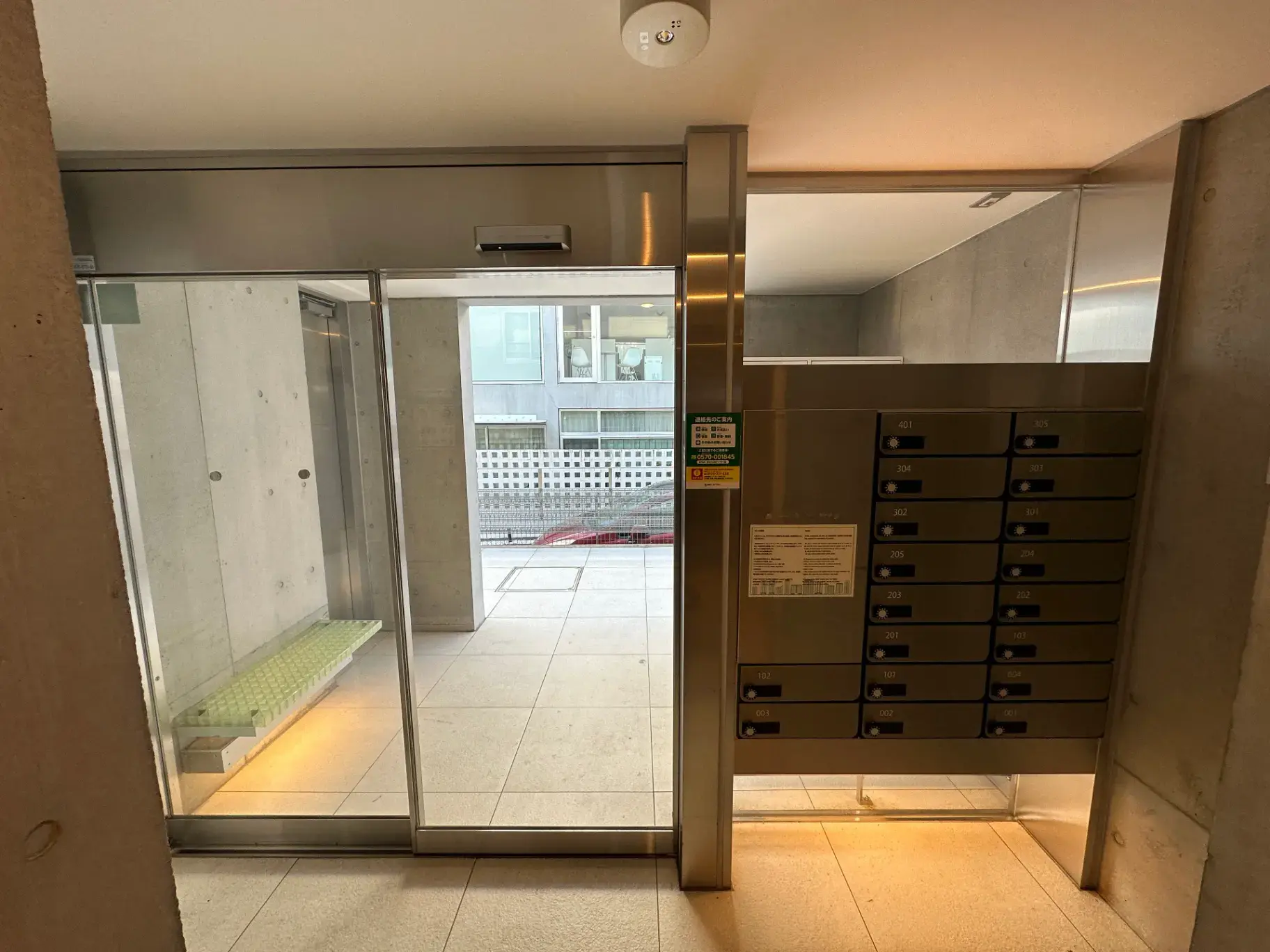 モダンなマンションのエントランスホール、自動ドアと郵便受け、クリーンなデザイン