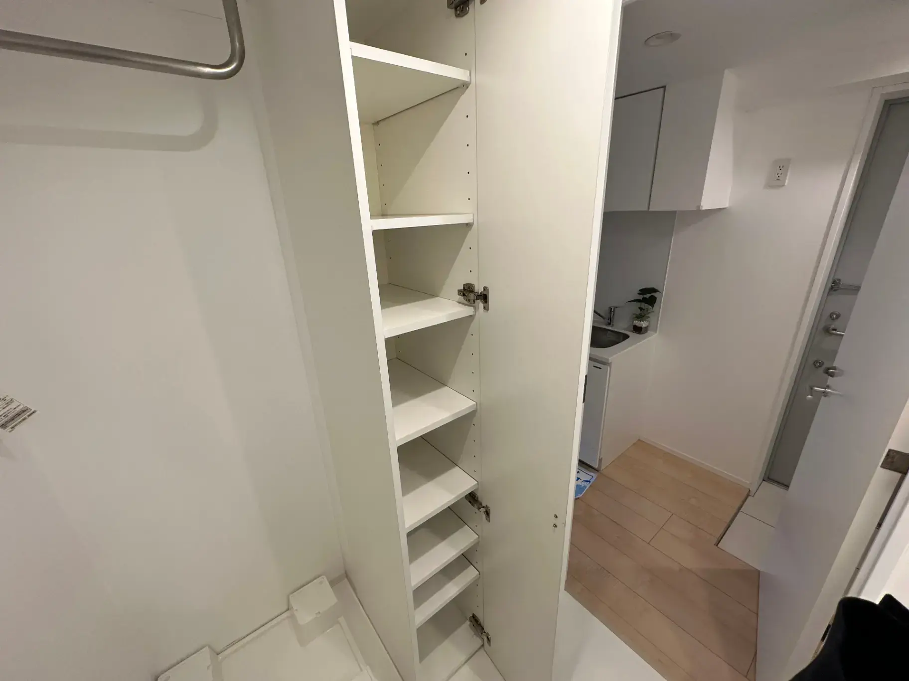 ミニマリストデザインの収納スペース、白いオープンシェルフ、クローゼットの扉が開いた状態