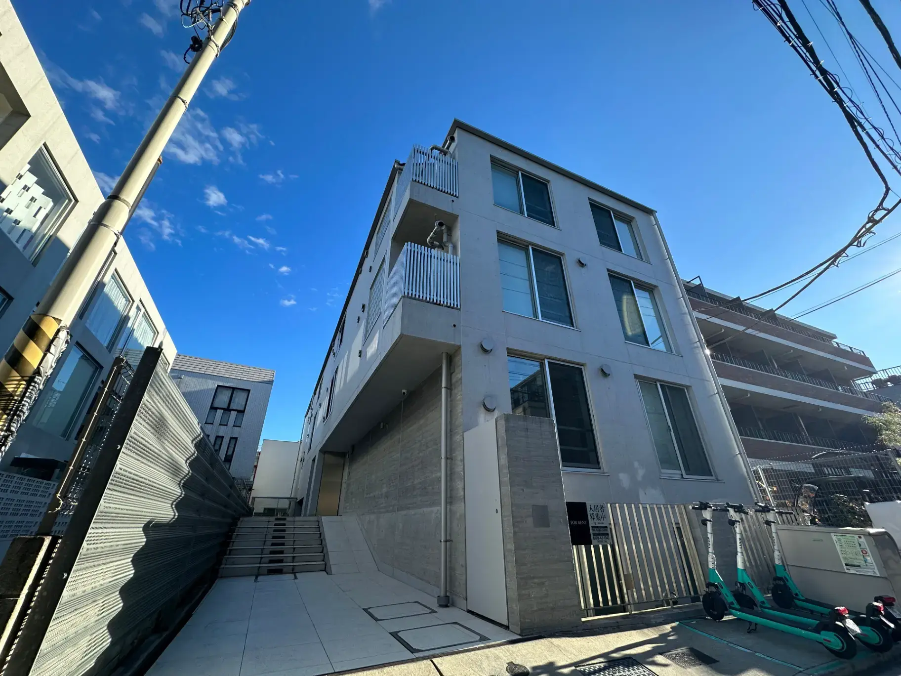 モダンなデザインのアパート外観、晴れた空とバルコニー