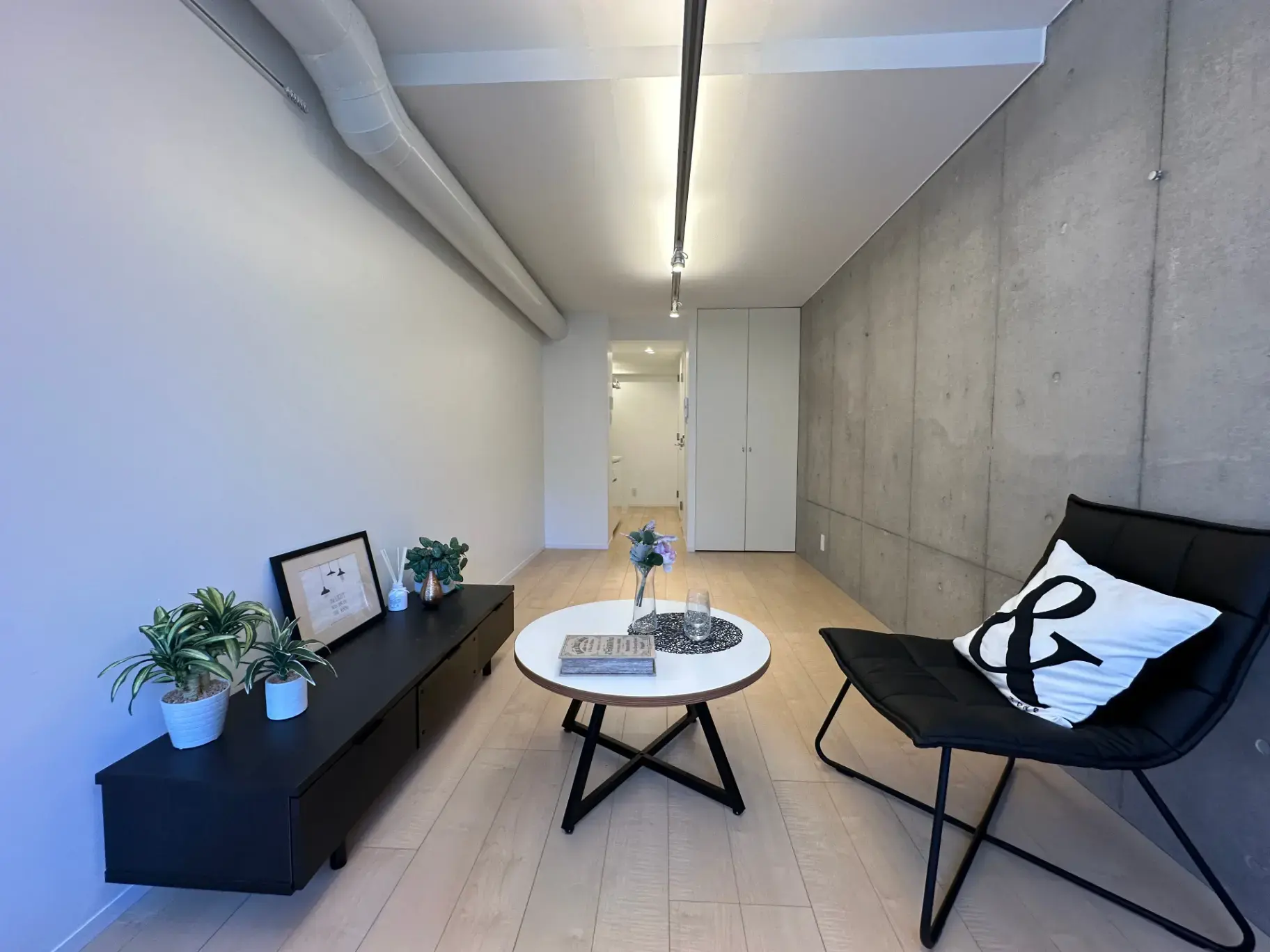 モダンなインテリアとコンクリート打ちっぱなしの壁が特徴的なリビングルーム