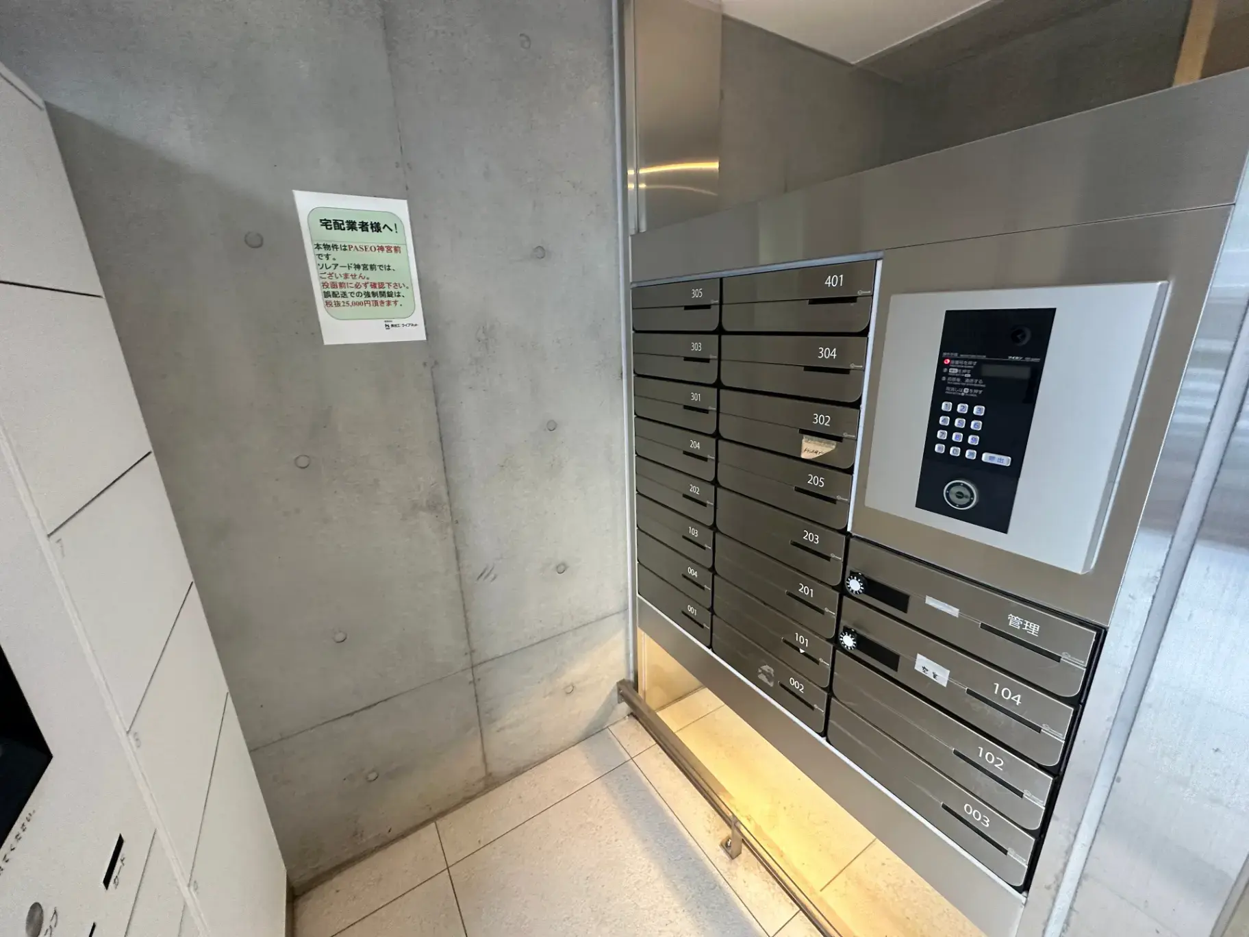 モダンなマンションの宅配ボックスとセキュリティシステム付きのインターホン