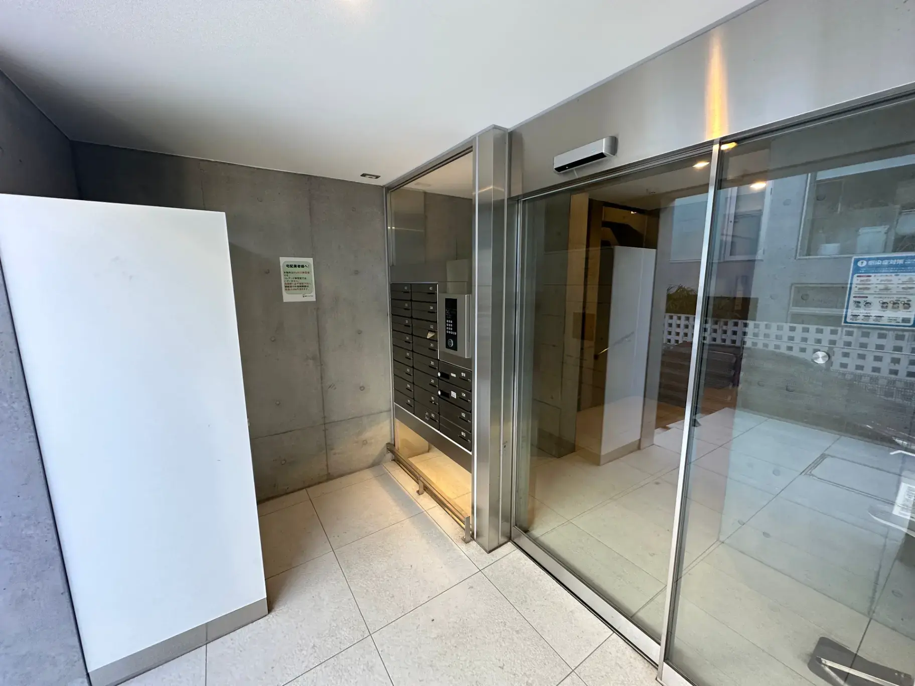 シンプルでモダンなエントランスホール、コンクリート打ちっぱなしの壁デザイン