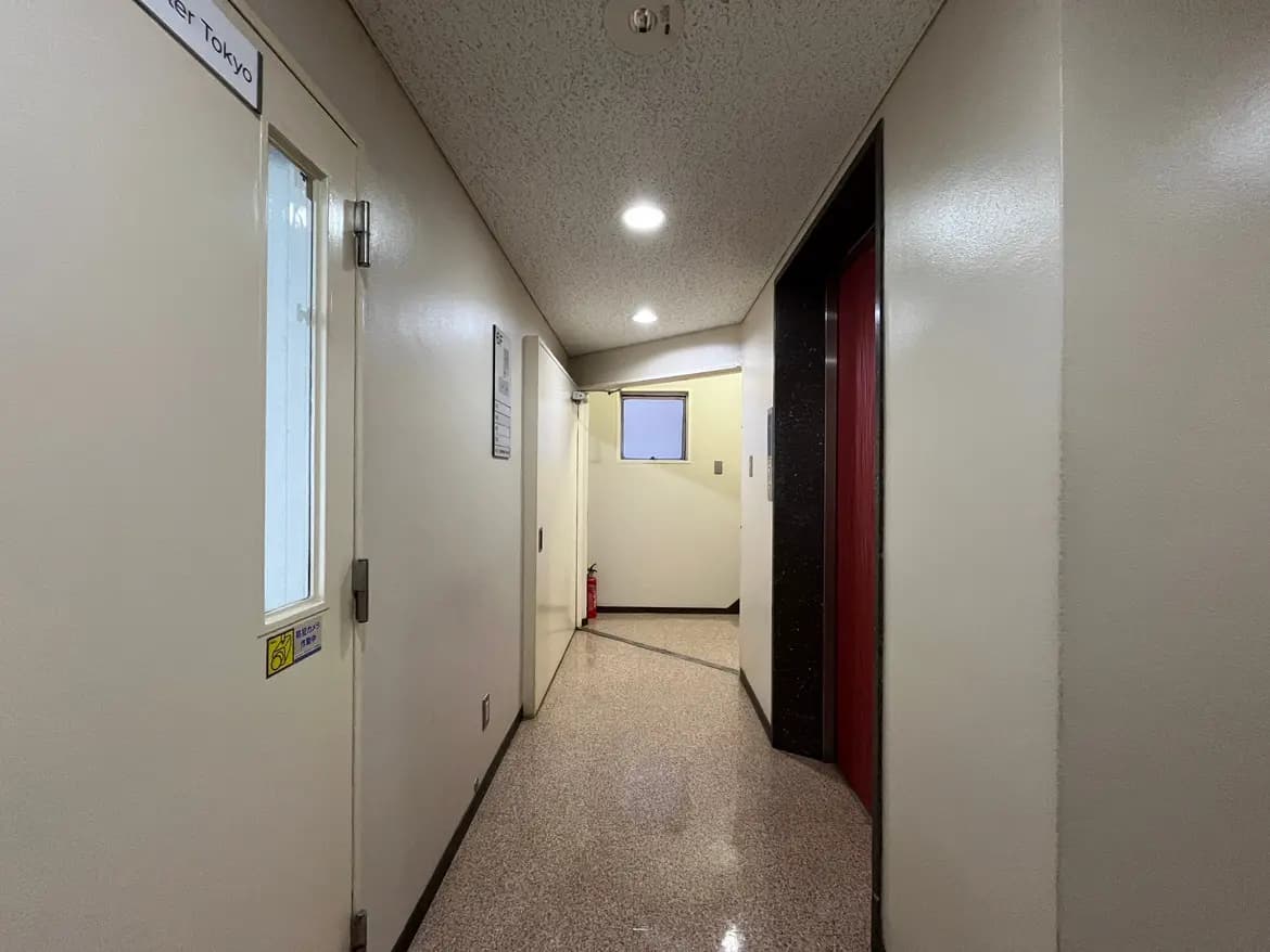 - 清潔感のある明るい廊下、両側にドアが並び、天井にはLED照明が設置されているインテリア