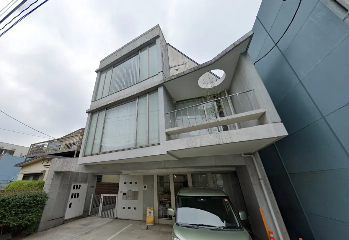 モダンな外観の建物、コンクリート製バルコニー、円形のデザインが特徴的なアパートメント