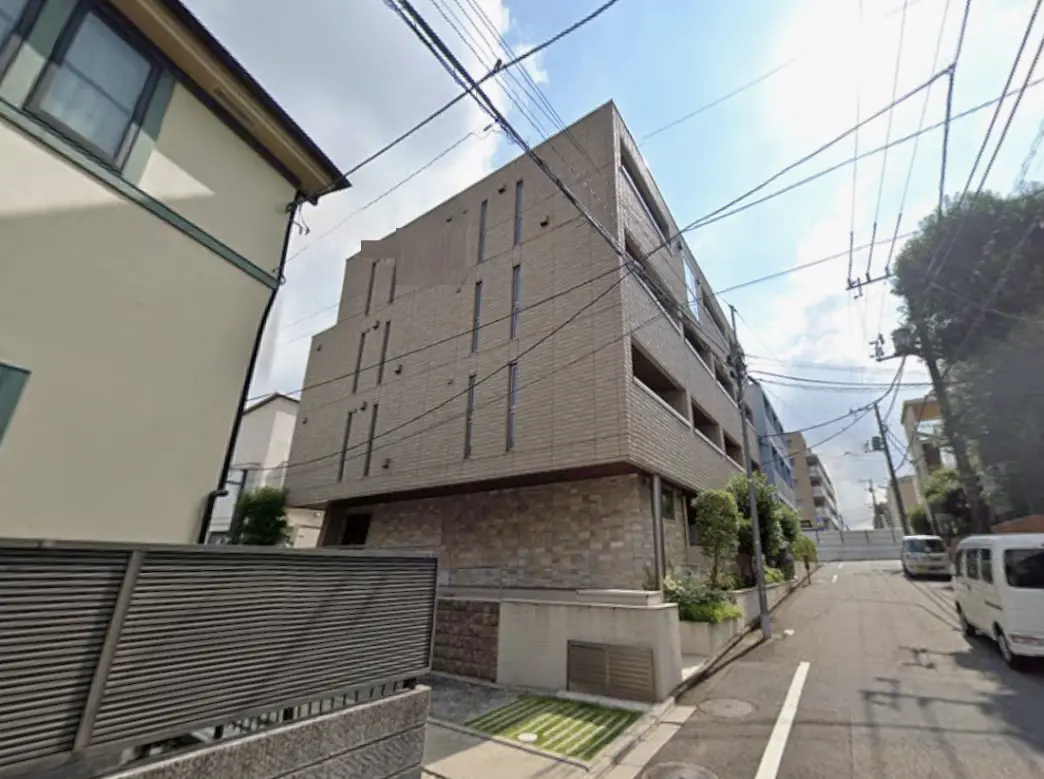 - モダンなデザインのアパート外観、隣には別棟があり、周囲には電線が張り巡らされた街並み