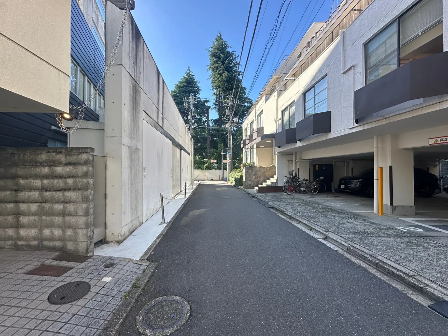 晴れた日の閑静な住宅街、舗装された道路とモダンな建物、駐車場が見える風景